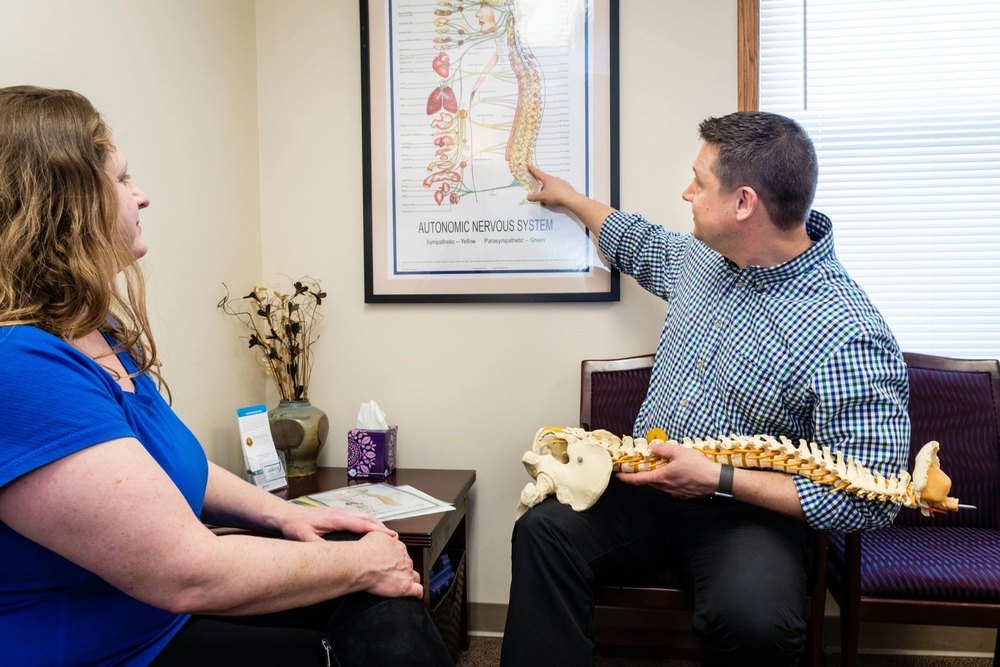 Dr. Matthew Wunderlich explaining a spinal chart to a patient in Fitchburg