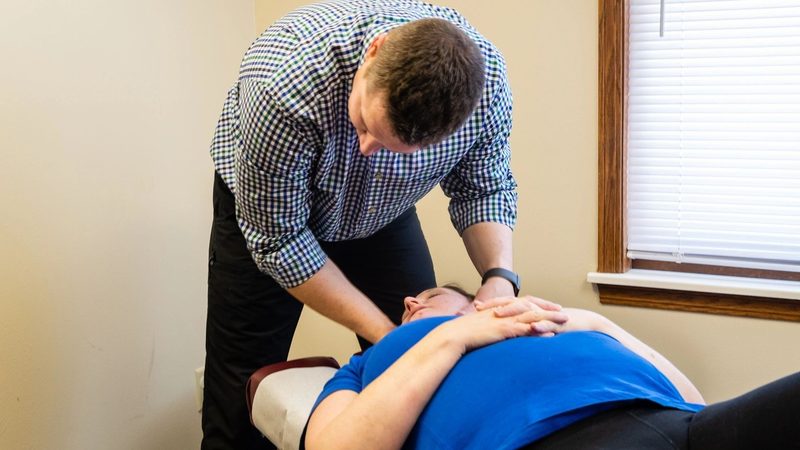 Dr. Matthew Wunderlich performing a spinal adjustment in Fitchburg